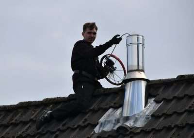 man in black jacket sitting on roof during daytime